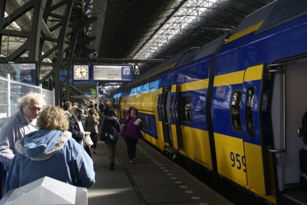 Reizigers wachten op trein naar Alkmaar, Amsterdam Centraal.