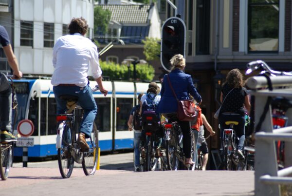 Fietsende man op Stadhouderskade wachtend bij stoplicht.