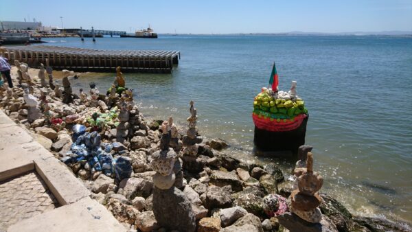 Straatartiest schildert stenen, Pra&ccedil;a do Com&eacute;rcio, Lissabon.