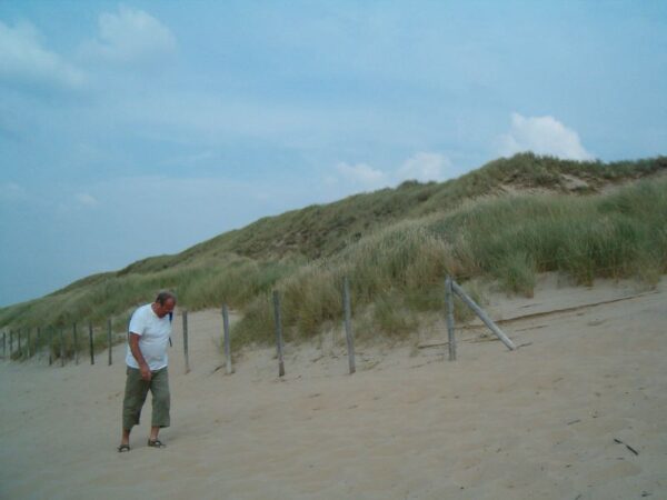 Mensen klimmen over duinen.