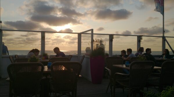 Zonsondergang midzomer, mensen genieten op terras.