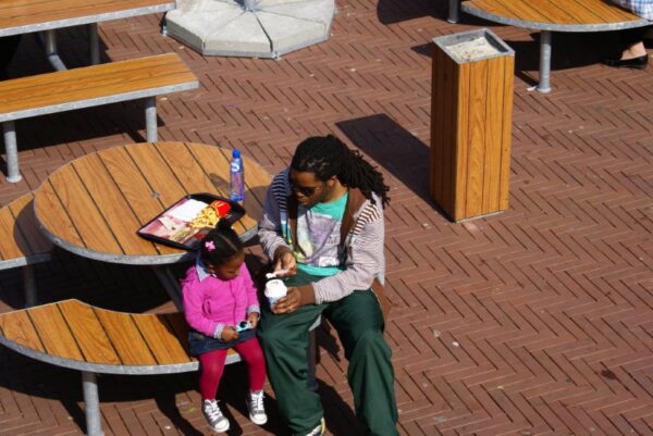 Vader en dochter genieten van een ijsje.