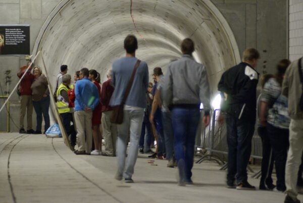 Mensen wachten bij tunnelbuis Amsterdam Centraal.
