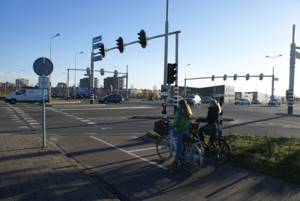 Meisjes op fiets wachten bij stoplicht Amstelveen.