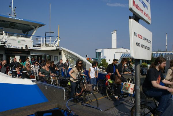 Wandelaars en fietsers verlaan veerpont Amsterdam Noord.
