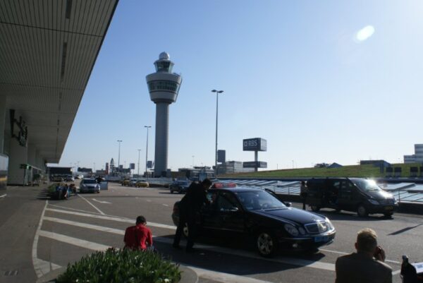 Taxi bij Schiphol, verkeerstoren op de achtergrond.