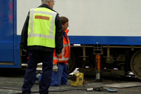 Tram wordt met pomp en sleepkabel terug op het spoor getrokken.