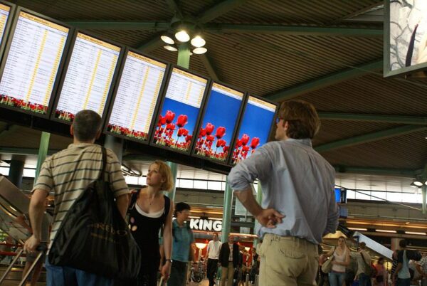 Man bekijkt vertrektijden Schiphol.