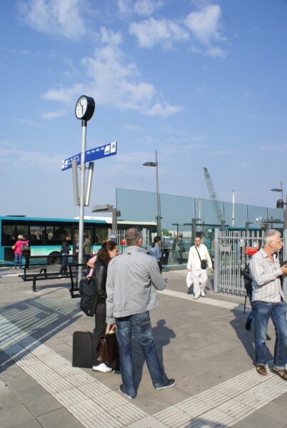 Wachtende mensen op busstation Amsterdam Centraal.