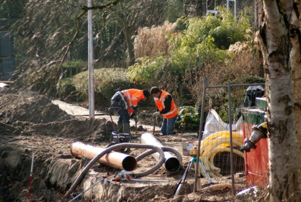 Werklui leggen riool aan in straat.