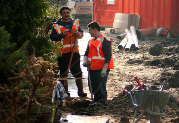 Werklui leggen riool aan in straat.