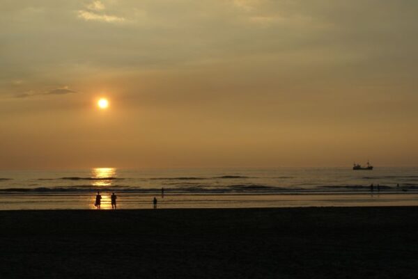 Zonsondergang Wijk aan Zee, boot en strandgangers.