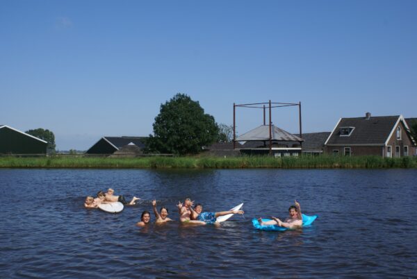 Kinderen spelen en zwemmen in de Amstel.